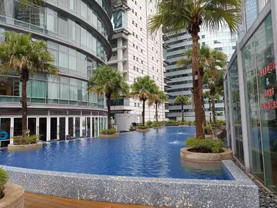 a swimming pool in the middle of a building with palm trees at KLCC Sky Villa Suites Vortex in Kuala Lumpur