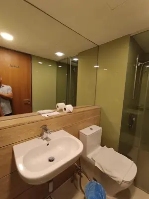 a bathroom with a sink and a toilet and a mirror at KLCC Sky Villa Suites Vortex in Kuala Lumpur