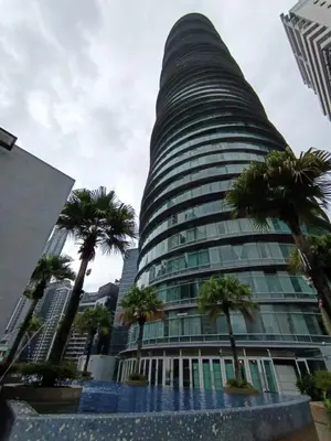 a tall building with palm trees in front of it at KLCC Sky Villa Suites Vortex in Kuala Lumpur