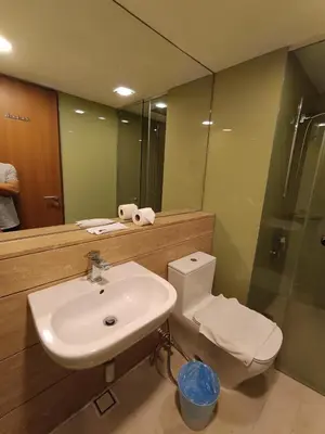 a bathroom with a sink and a toilet and a mirror at KLCC Sky Villa Suites Vortex in Kuala Lumpur