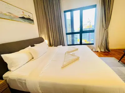 a bedroom with a large white bed with a large window at KLCC Sky Villa Suites The Mews in Kuala Lumpur