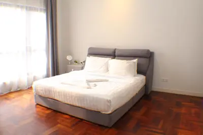 a bedroom with a large bed with white sheets at KLCC Sky Villa Suites The Mews in Kuala Lumpur