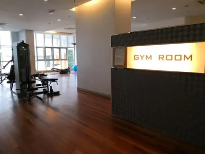 an office with a gym room with a table and chairs at Regalia Suites Kuala Lumpur by Cozyvista Suites in Kuala Lumpur