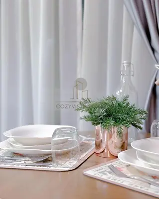 a wooden table with plates and dishes on it at Regalia Suites Kuala Lumpur by Cozyvista Suites in Kuala Lumpur