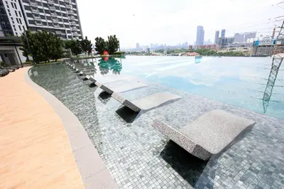 a pool with benches in the middle of a city at M Vertica KL City Residences by Vivid Stay in Kuala Lumpur