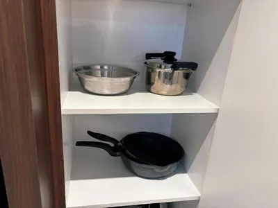 a shelf with two pots and a frying pan on it at KLCC Bukit Bintang Anggun Residence 5min walk to Monorail station in Kuala Lumpur