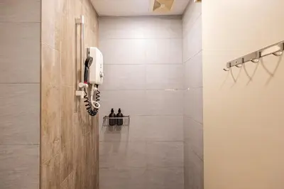 a bathroom with a shower with a phone on the wall at Blossom Playground with kids friendly home Arte Plus in Kuala Lumpur