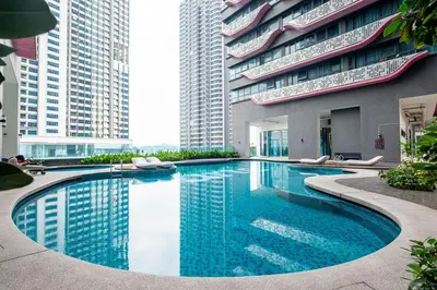 a swimming pool in the middle of a building with tall buildings at Blossom Playground with kids friendly home Arte Plus in Kuala Lumpur