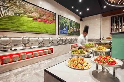 a chef preparing food in a kitchen with plates of food at The Platinum KLCC By Aura Suites in Kuala Lumpur