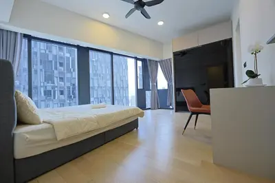 a bedroom with a bed and a table and chairs at Star Residences By Minos Homestay in Kuala Lumpur