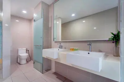 a bathroom with a sink and a toilet and a mirror at Karaoke Party Penthouse at KL Gateway by Cobnb in Kuala Lumpur
