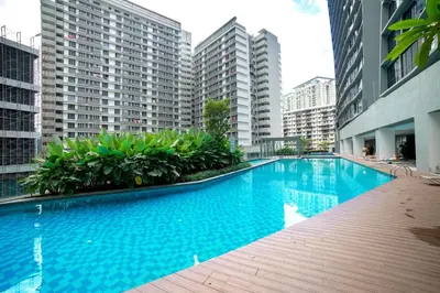 a large swimming pool in a city with tall buildings at Karaoke Party Penthouse at KL Gateway by Cobnb in Kuala Lumpur