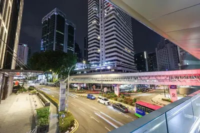 a city street at night with buildings and cars at KAĨTE Suites at Wisma Cosway Sky Bridge to Pavilion KL in Kuala Lumpur