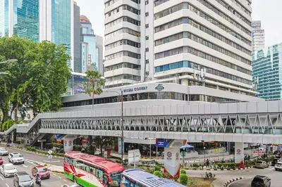 a building with a train over a street with traffic at KAĨTE Suites at Wisma Cosway Sky Bridge to Pavilion KL in Kuala Lumpur