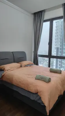 a bed with two pillows on it in front of a window at KL29 3BR4B Jalan Ampang Near KLCC in Kuala Lumpur