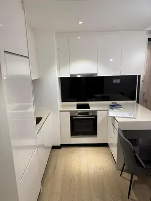a kitchen with white cabinets and a black microwave at KL Star Residences KLCC By Nexus 38 in Kuala Lumpur