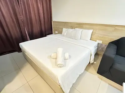 a hotel room with a bed with two towels on it at Taragon Luxury Suites Bukit Bintang,Kuala Lumpur in Kuala Lumpur