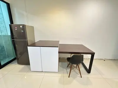 a table and a refrigerator and a table and a chair at Taragon Luxury Suites Bukit Bintang,Kuala Lumpur in Kuala Lumpur