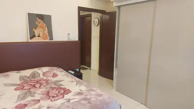 a bedroom with a bed and a painting of a woman at Damas Plaza-Hartamas in Kuala Lumpur