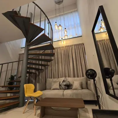 a living room with a couch and a spiral staircase at 3 Tower Ampang Suite in Kuala Lumpur