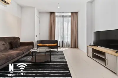 a living room with a couch and a flat screen tv at Arcoris Mont Kiara 3 min to 163mall 2 Bed in Kuala Lumpur