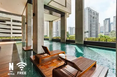 a swimming pool with two chairs in a building at Arcoris Mont Kiara 3 min to 163mall 2 Bed in Kuala Lumpur