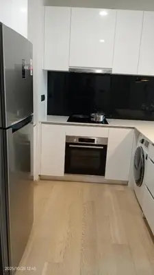 a kitchen with white cabinets and a stainless steel appliance at Star klcc by AR Accommodation in Kuala Lumpur