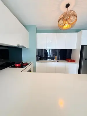 a kitchen with white cabinets and a chandelier at Star klcc by AR Accommodation in Kuala Lumpur