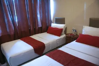 two beds in a room with red and white at Hotel City Bukit Bintang in Kuala Lumpur