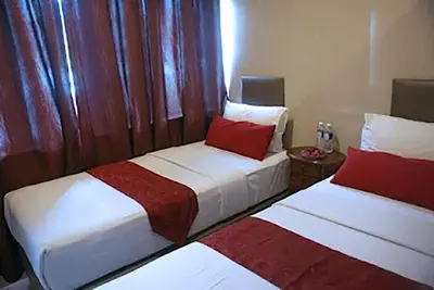 two beds in a small room with red pillows at Hotel City Bukit Bintang in Kuala Lumpur