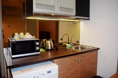 a kitchen counter with a microwave and a sink at Taragon Residences in Kuala Lumpur
