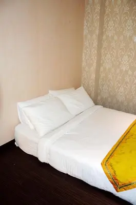 a bed with white sheets and pillows in a room at Taragon Residences in Kuala Lumpur