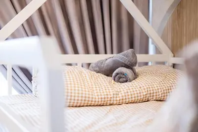 a stuffed animal is laying on a pillow in a crib at Majestic Residence By Feel Home in Kuala Lumpur