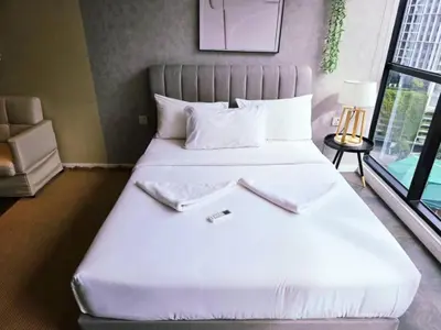 a bed with white sheets and pillows in a room at Scarletz KLCC By AR Hospitality in Kuala Lumpur