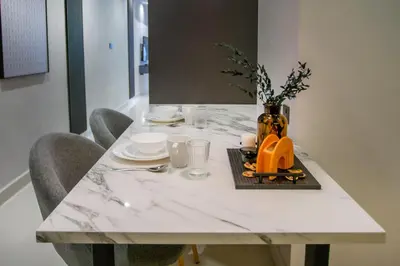 a white marble table with chairs and a vase on it at NOVO Ampang Modern Studio Infinity Pool near KLCC & Gleneagles in Kuala Lumpur