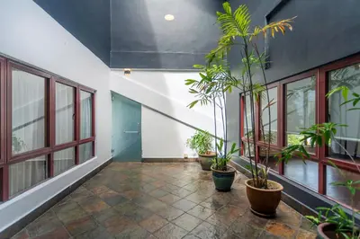 a hallway with potted plants and windows in a building at Embassy Villa by COBNB, Top Floor Unit at Ampang Hilir in Kuala Lumpur