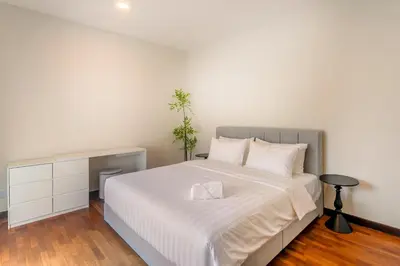a bedroom with a bed with a white bedspread at Embassy Villa by COBNB, Top Floor Unit at Ampang Hilir in Kuala Lumpur