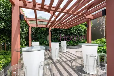 a pergola with stools and tables on a patio at Majestic Residence Premier Suites Kuala Lumpur in Kuala Lumpur