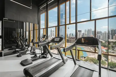 a gym with cardio machines and a view of the city at Blueground Kuala Lumpur pool nr Lake Gardens KUL-1 in Kuala Lumpur