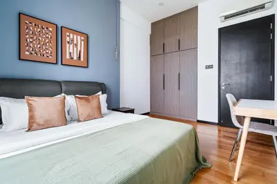 a bedroom with a bed and a table and a desk at Blueground Kuala Lumpur city view nr KL Bird Park KUL-2 in Kuala Lumpur