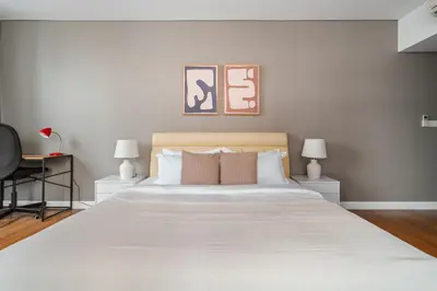a bedroom with a large white bed with two lamps at Blueground Kuala Lumpur pool nr KL Tower KUL-5 in Kuala Lumpur