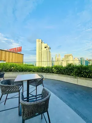 a table and chairs on a balcony with a city skyline at Majestic Residence KLCC By AFA in Kuala Lumpur