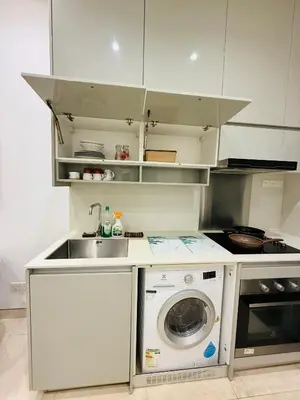 a kitchen with a sink and a washing machine at Lucentia Cozy Comfort Infinity Pool Suites in Kuala Lumpur