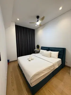 a bedroom with a large bed with white sheets at Lucentia Cozy Comfort Infinity Pool Suites in Kuala Lumpur