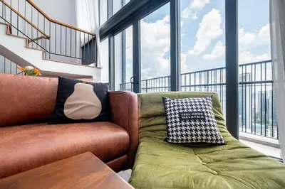 a living room with a couch and a table and windows at Isola KLCC By Feel Home in Kuala Lumpur