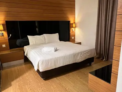 a bedroom with a large bed with a wooden headboard at Suit Unit at Dua Sentral in Kuala Lumpur