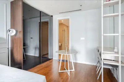 a white room with a table and a bed at Luxury Living Hostel in Kuala Lumpur