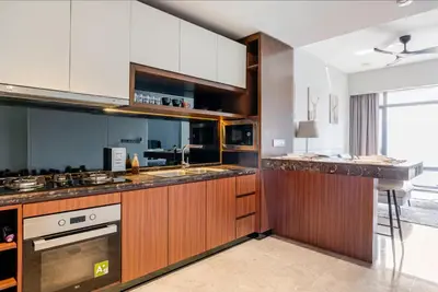 a large kitchen with wooden cabinets and a sink at Luxury Living Hostel in Kuala Lumpur