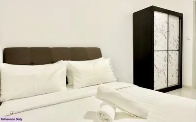 a white bed with white pillows and a black cabinet at The Heart in Kuala Lumpur City - Majestic Residences in Kuala Lumpur