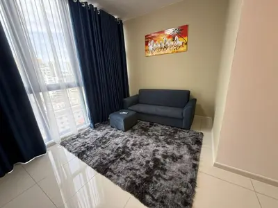 a living room with a blue couch and a rug at Majestic Residence KL in Kuala Lumpur